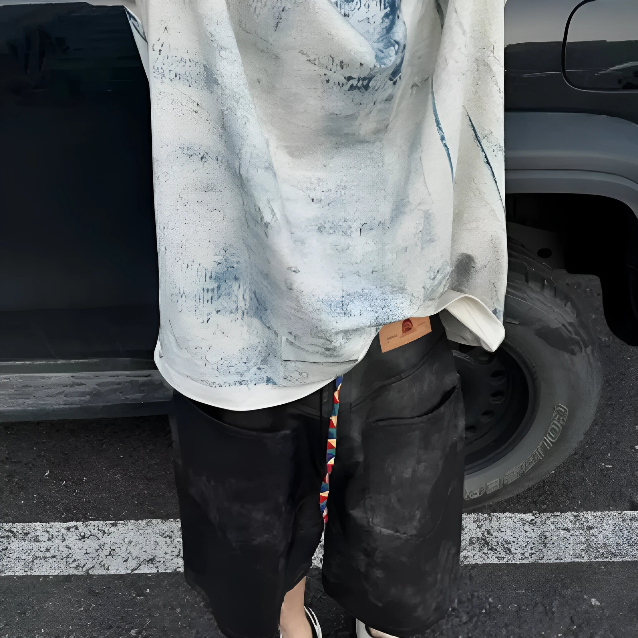 Man modelling a loose-fit, short-sleeved T-shirt with a blue and white tie-dye print pattern.