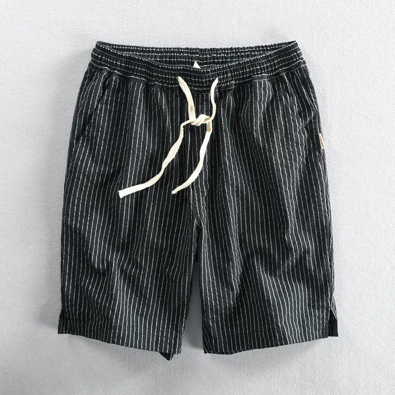 Man wearing striped casual cotton shorts with a loose straight fit and mid waist, showcasing the micro elastic fabric.