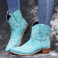 Women's blue embroidered cowboy ankle boots with a low wedge heel and pointed toe.