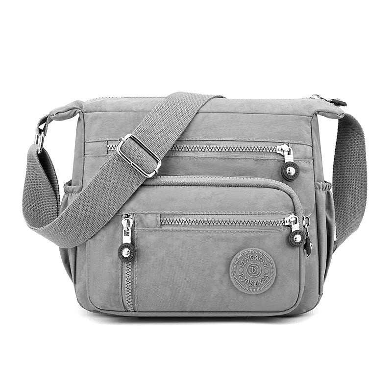 Grey nylon shoulder messenger bag with single strap and square vertical design