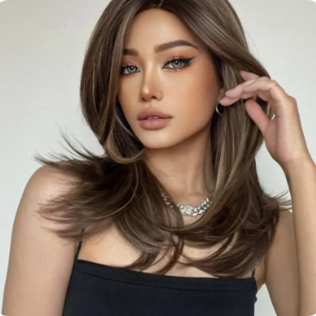 Mid-length curly synthetic wig with gradient colour and long bangs on a wig stand.