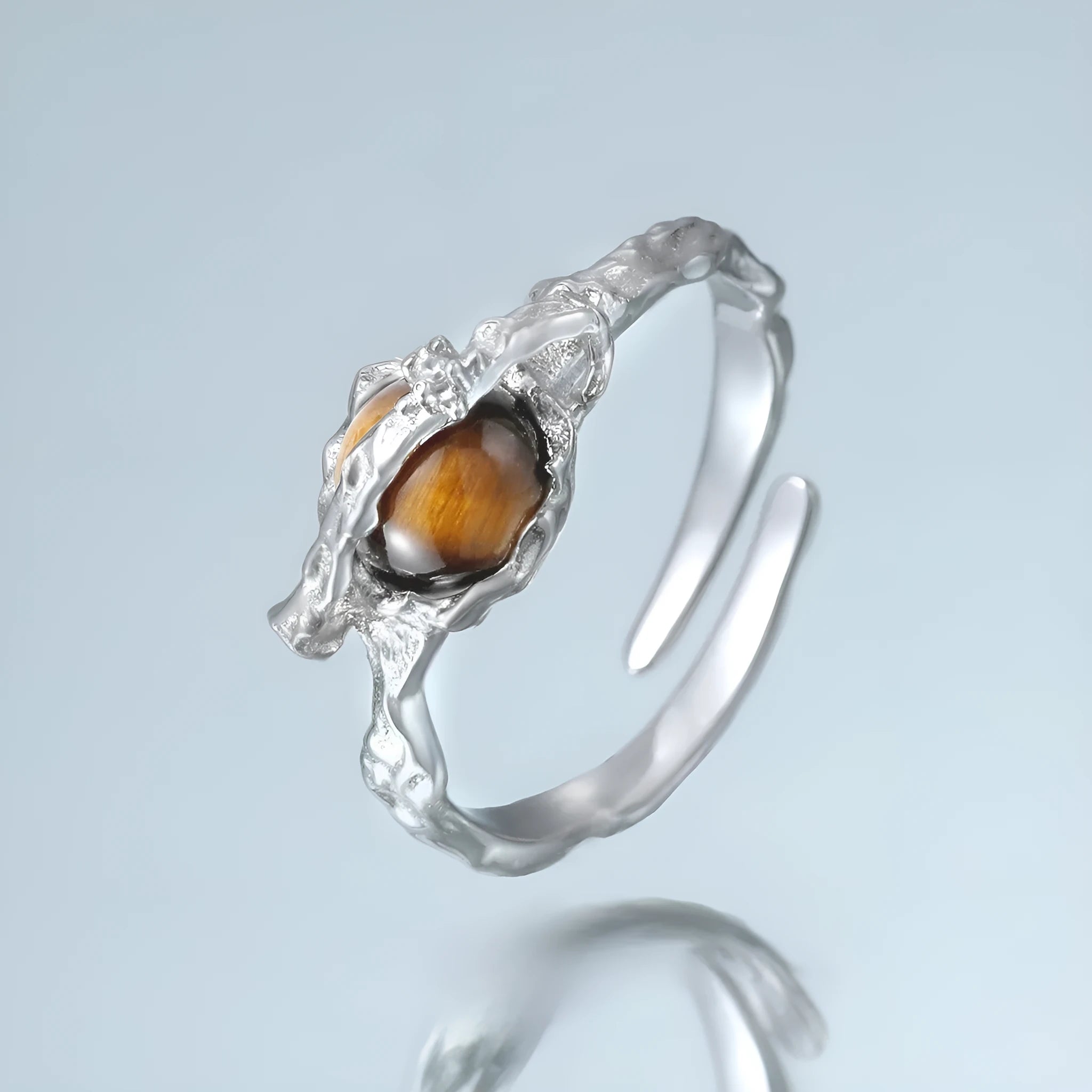 Saturn-themed adjustable open ring in electroplated white gold colour with tigereye gemstone detail