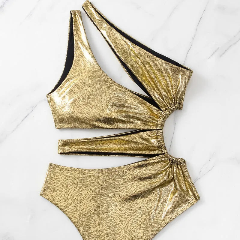 Women's solid gold backless one-piece swimsuit on a model.