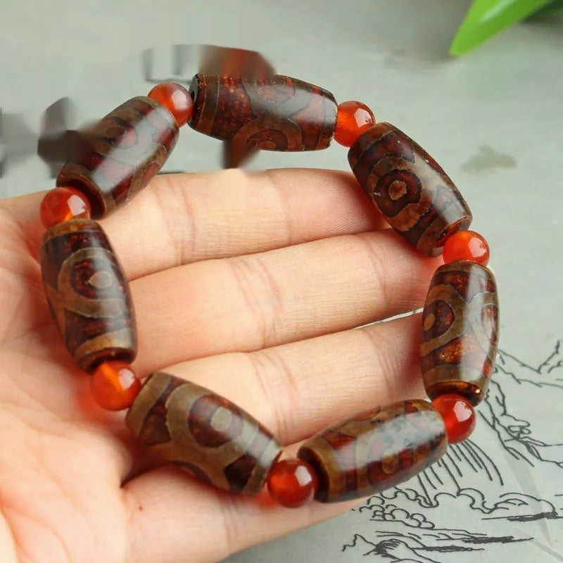 Distressed agate Tibet bead bracelet with three-eye motifs and multiple traditional bead styles on wrist