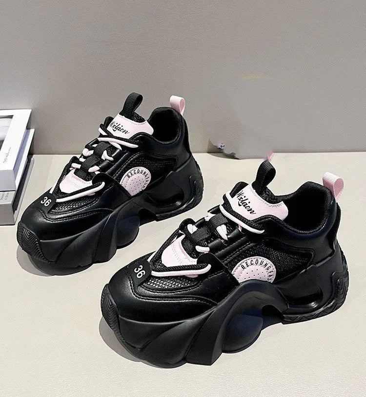 Women's pink platform sneakers with a thick sole and cross ankle straps on a white background.