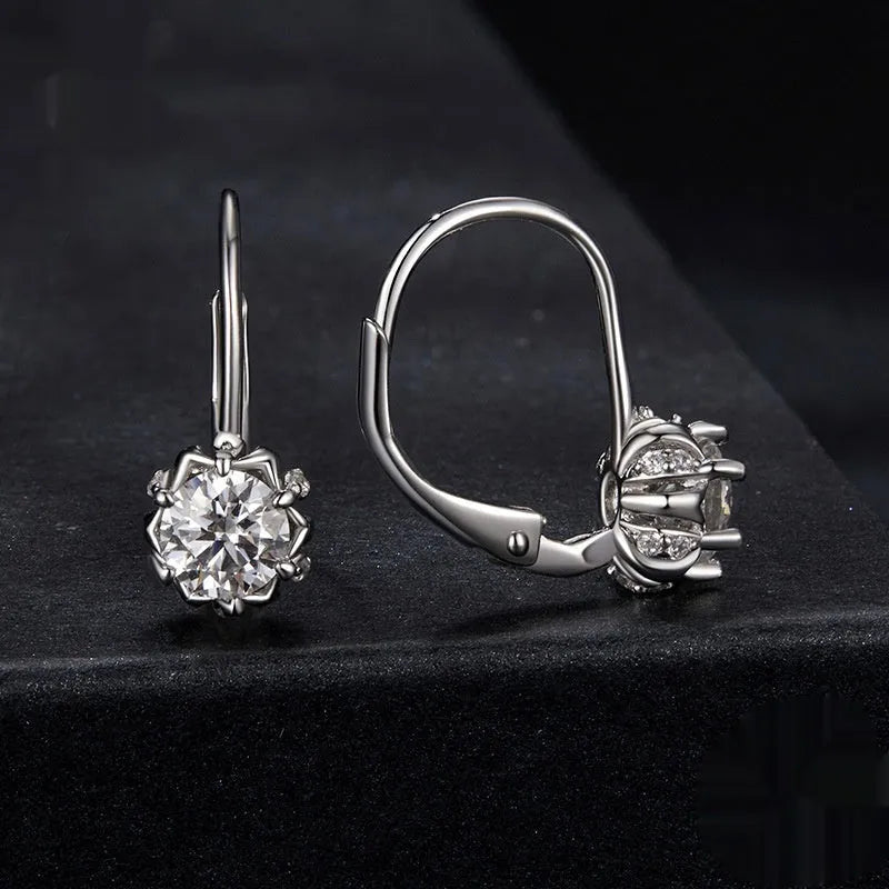 Sterling silver flower bud shaped ear clips with a white gold plated finish and a central moissanite stone.