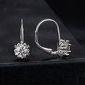 Sterling silver flower bud shaped ear clips with a white gold plated finish and a central moissanite stone.