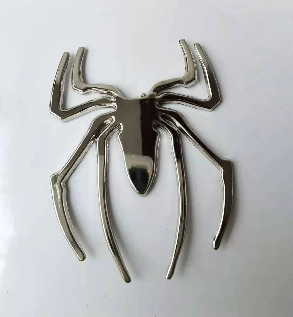 Three-dimensional metal spider car bumper sticker in zinc alloy, shown in gold colour.