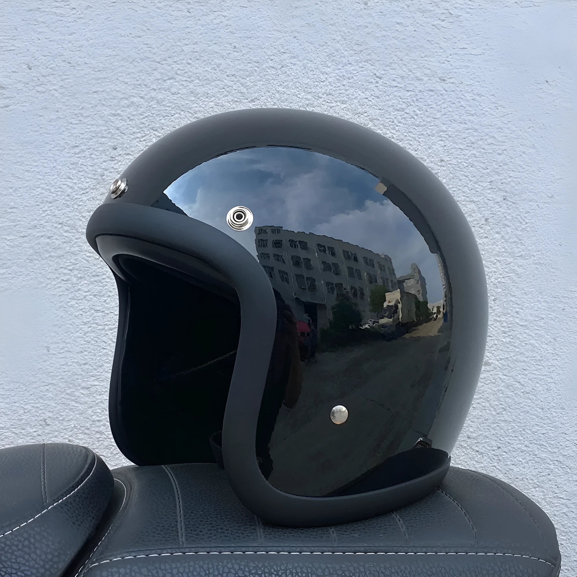 A retro-style motorcycle half helmet made from grey fibreglass, shown from the side.