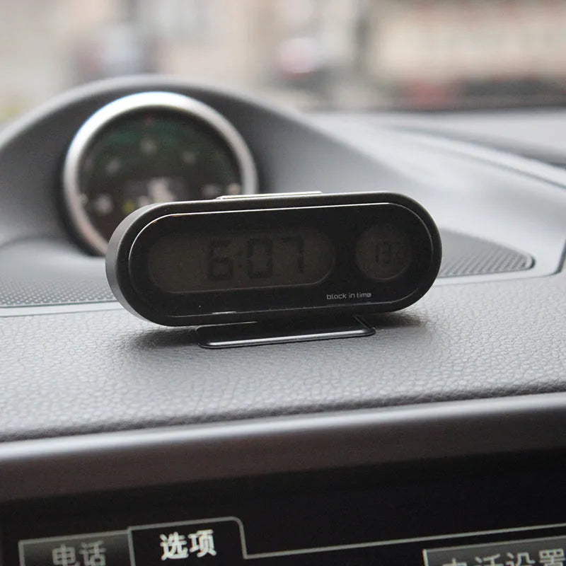 Black car clock thermometer with luminous LED display showing time and temperature on adjustable dashboard bracket