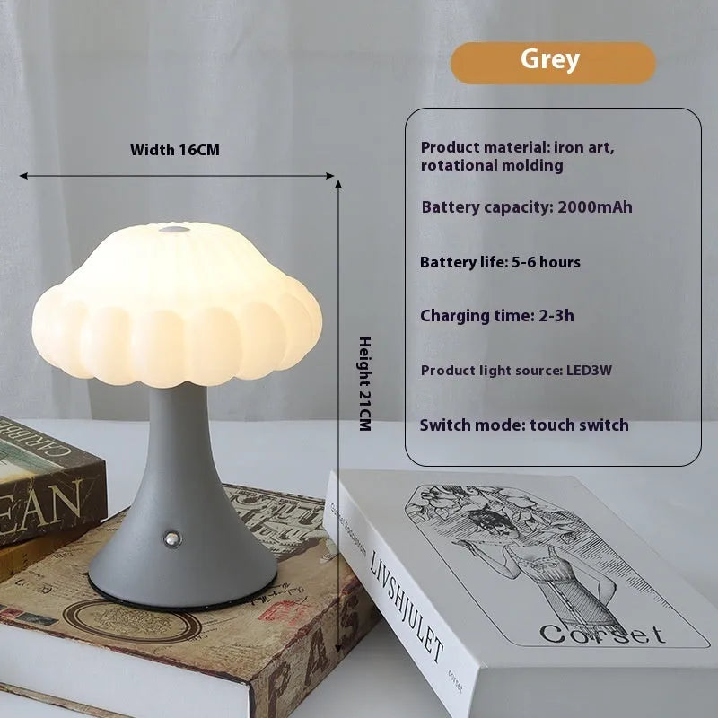 Mushroom-shaped touch control night light in cream colour on a wooden table.