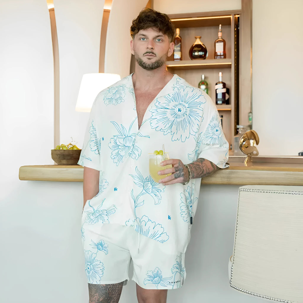 A man's loose grey short-sleeved cardigan with a floral print, showing the elastic band fabric.