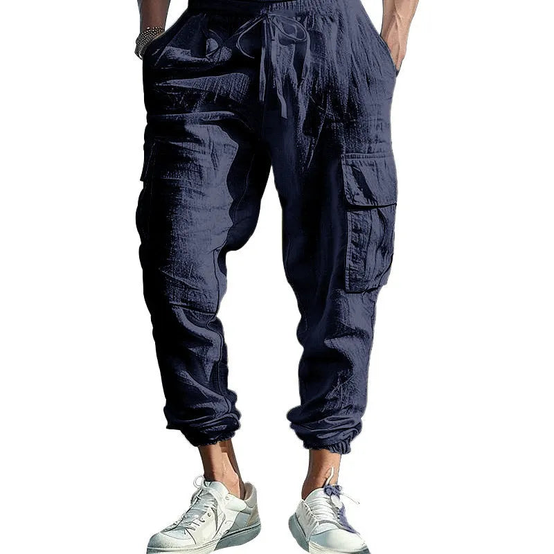 Men's solid colour linen casual trousers with ankle ties and drawstring waist on hanger.