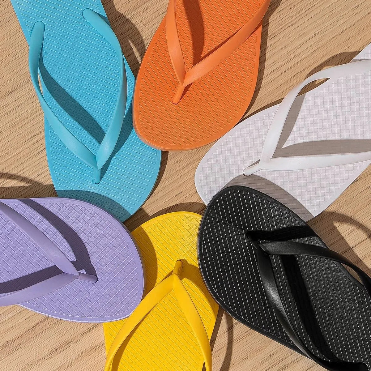 Foldable non-slip beach slippers in orange colour showing hollow-out design and PVC sole.