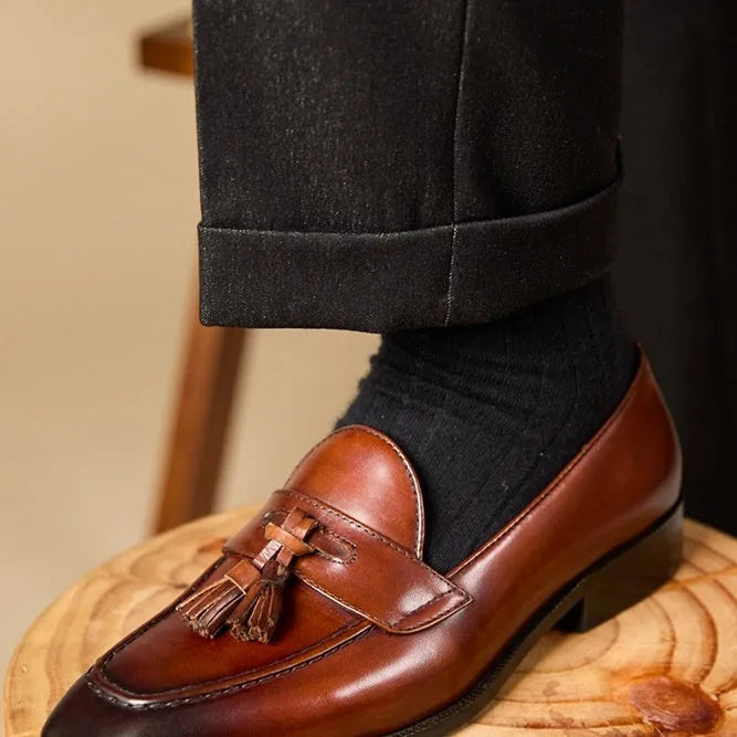 Men's leather tassel loafers in black and brown with polished finish and rubber soles