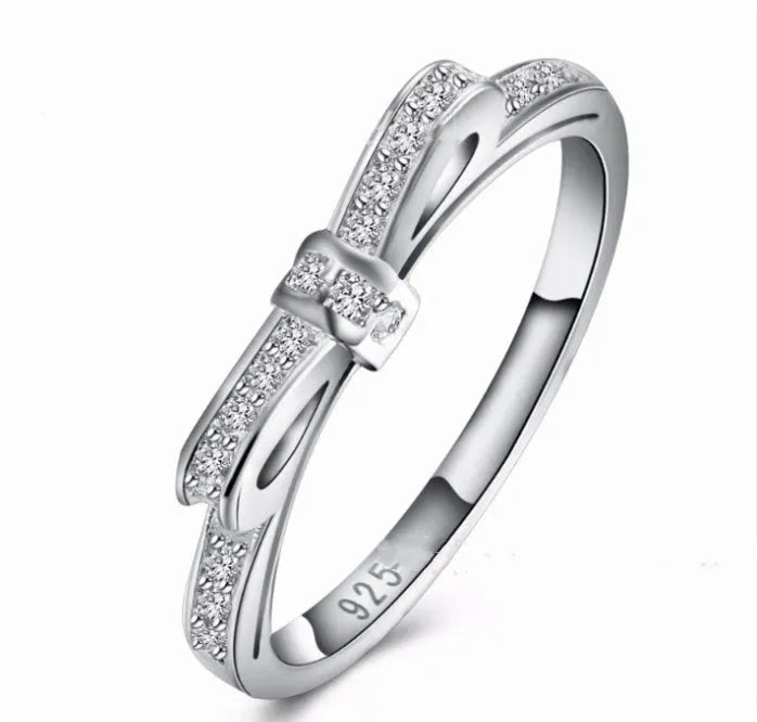 Silver electroplated ring with a bow shape design set with rhinestones and zircon crystals.