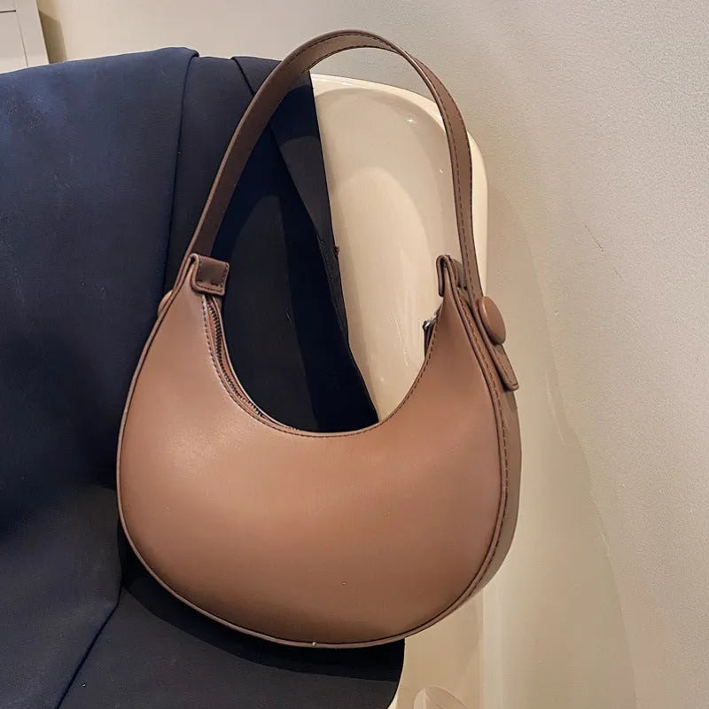 Women's retro-style PU shoulder bag in a dumpling shape, shown in cream yellow colour with a shoulder strap.