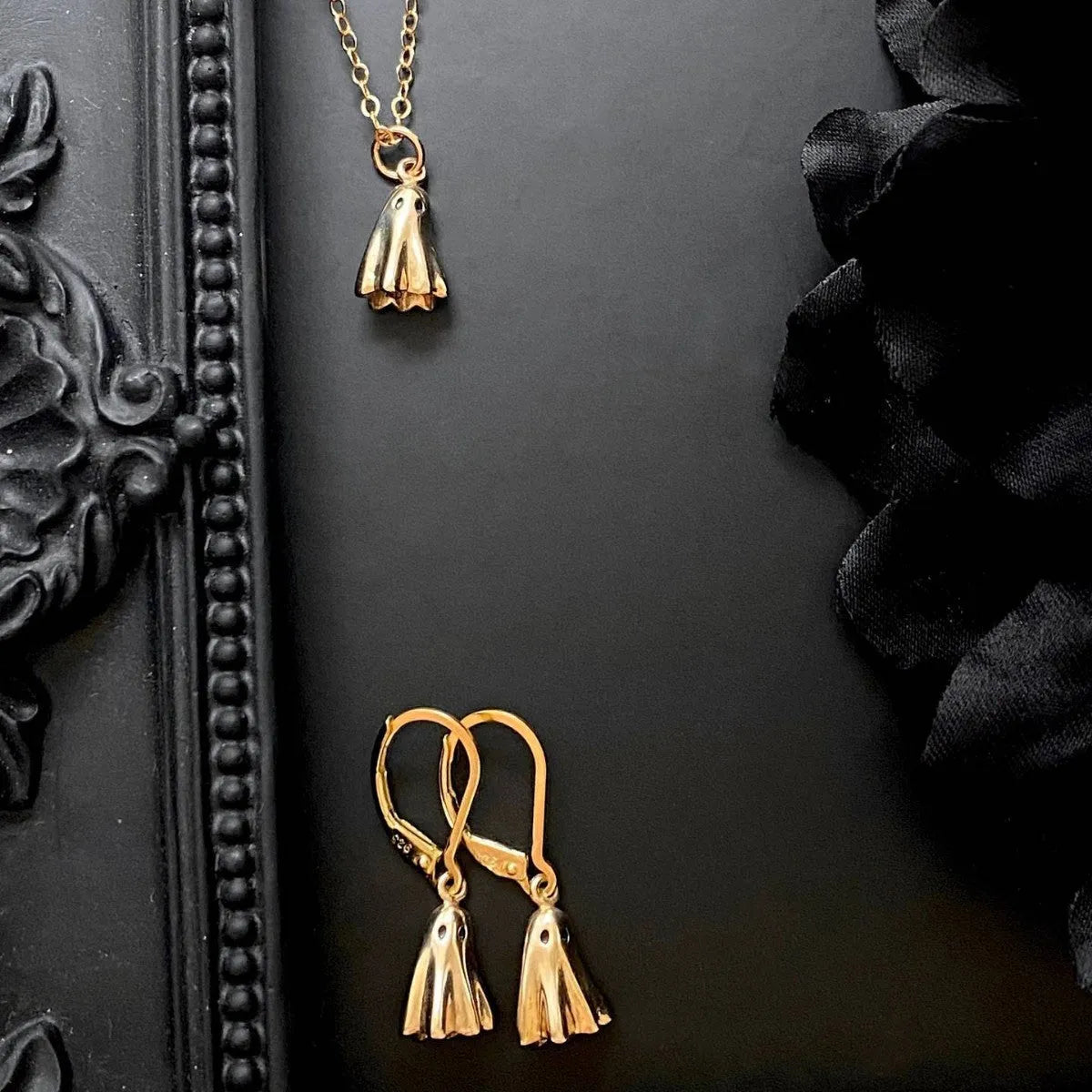 A ghost pendant necklace on a twisted stainless steel chain, showing the titanium steel electroplated pendant.