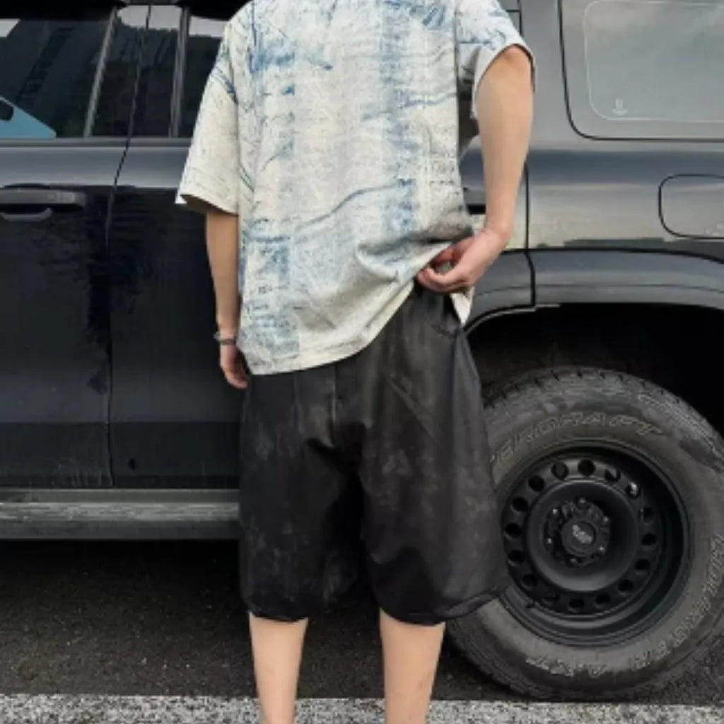 Man modelling a loose-fit, short-sleeved T-shirt with a blue and white tie-dye print pattern.