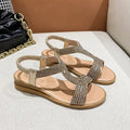 Gold women's patent leather beach sandals with rhinestones on the strap and a round toe.