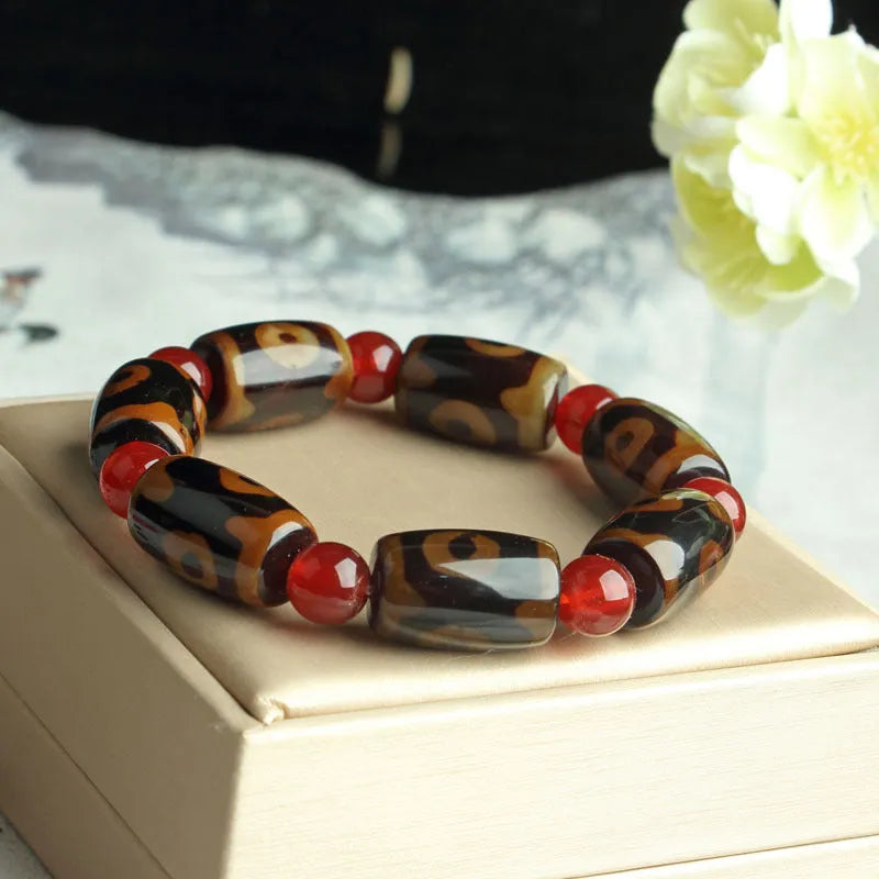 Distressed agate Tibet bead bracelet with three-eye motifs and multiple traditional bead styles on wrist
