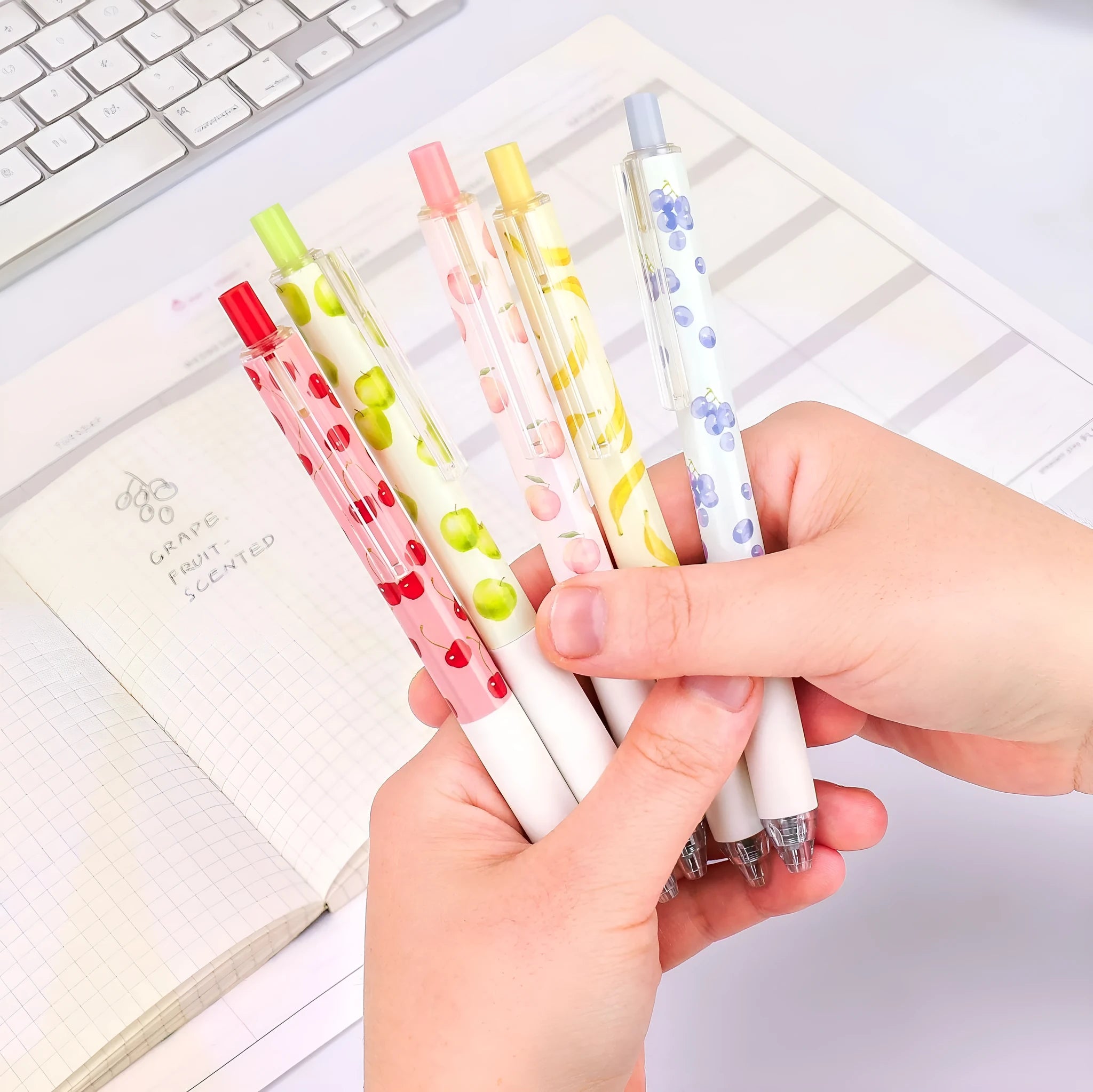 Three scented fruit pens with 0.5mm black ink and press mechanism on white background