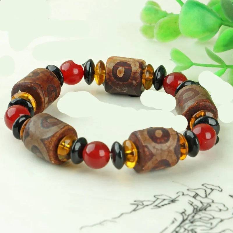 Distressed agate Tibet bead bracelet with three-eye motifs and multiple traditional bead styles on wrist