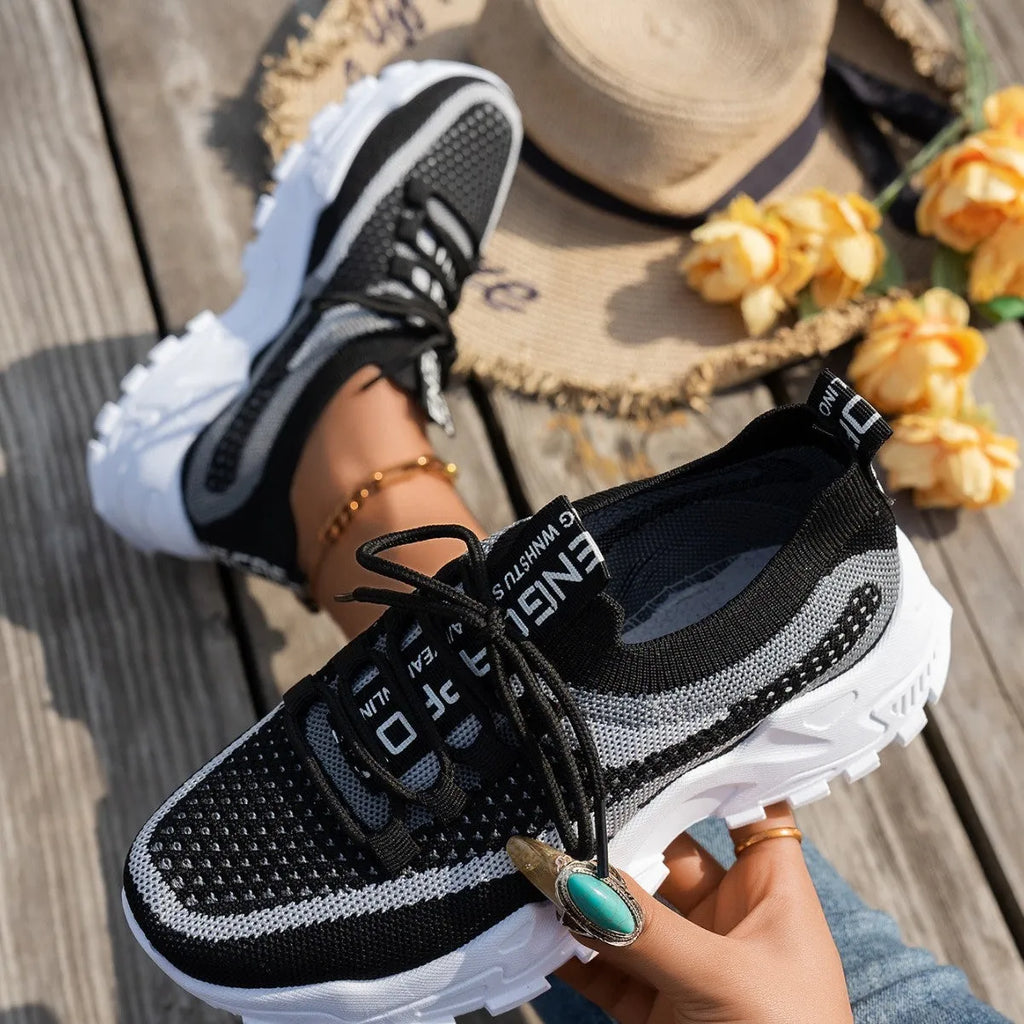 Women's low heel Flyknit mesh sneakers in a grey colour scheme with lace-up front.