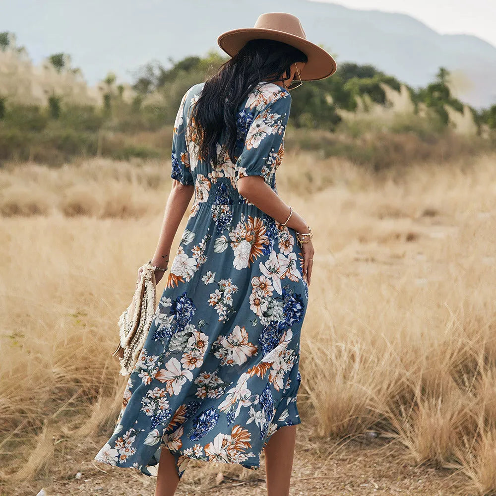 Yellow floral print women's dress with v-neck, short sleeves, elastic high waist, and a large hemline midi skirt.