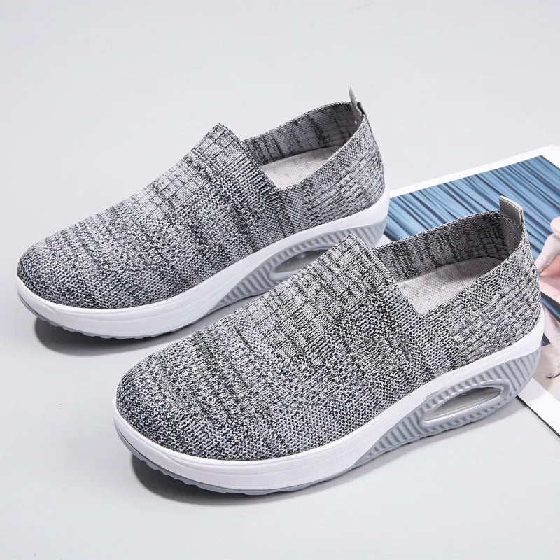 Women's black mesh running shoes with air cushion midsole and round toe on a grey background.