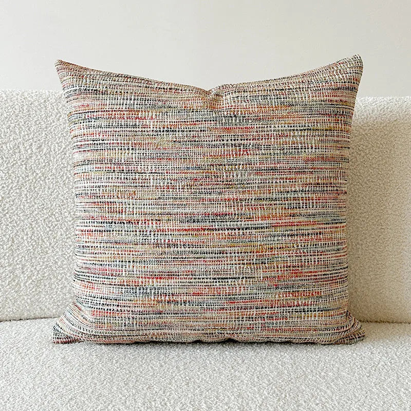 Amber jacquard paisley pillow cover on a sofa, showing textured fabric and botanical pattern.