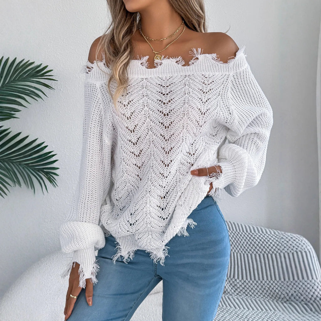 White hollow-out patterned long-sleeved sweater with a cut off-the-shoulder neckline on a model.