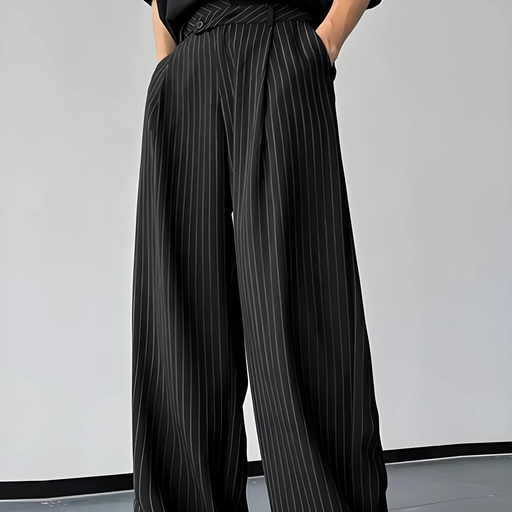 Man wearing black vertical stripe pleated casual trousers.