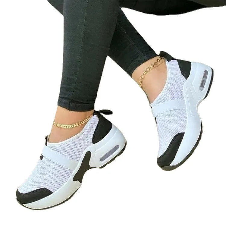 Women's white mesh sneakers with a rubber sole and round toe, shown on a light background.