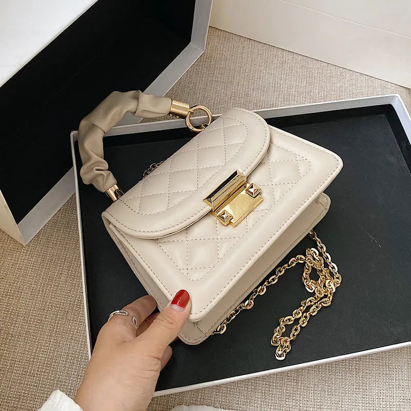 Purple rhombus-shaped women's shoulder bag with crossbody strap on mannequin