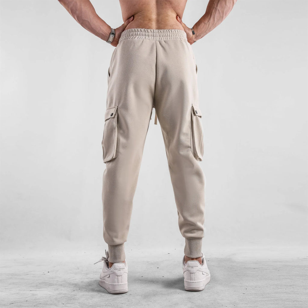 Men's loose cotton trousers with ankle ties in apricot colour showing multi-pocket design