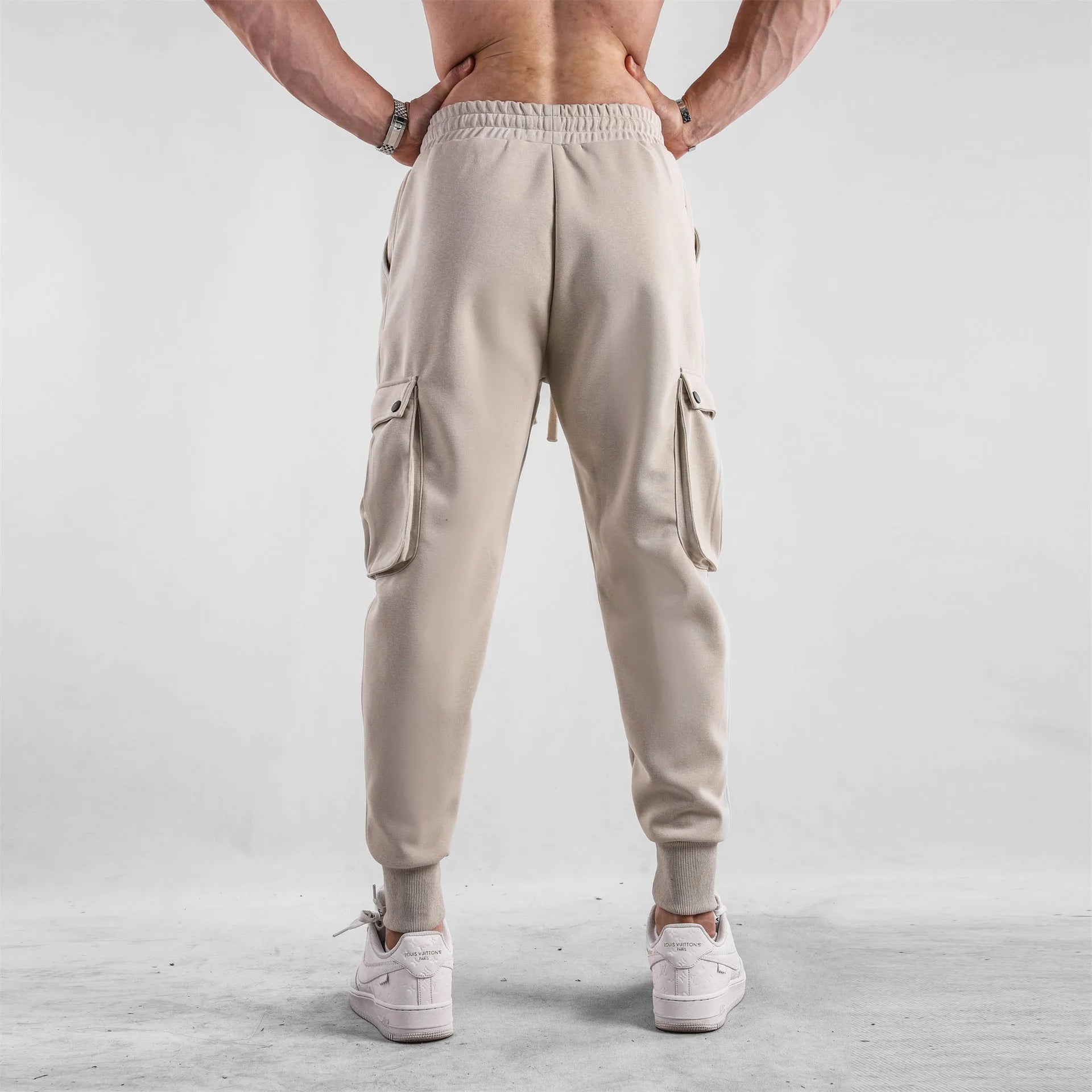 Men's loose cotton trousers with ankle ties in apricot colour showing multi-pocket design