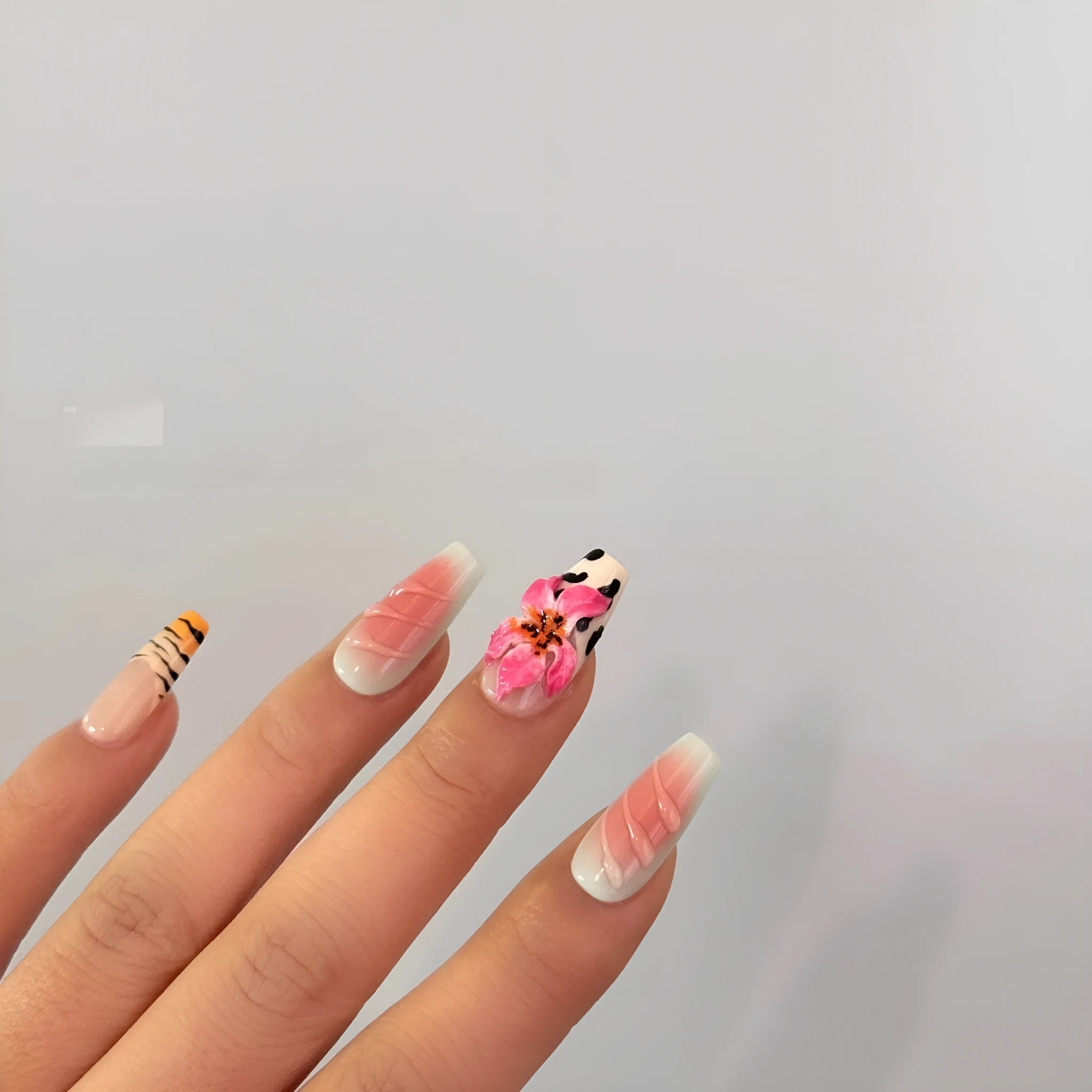 Zebra pattern and Lily hand carving design on a set of long, decorative false nails.