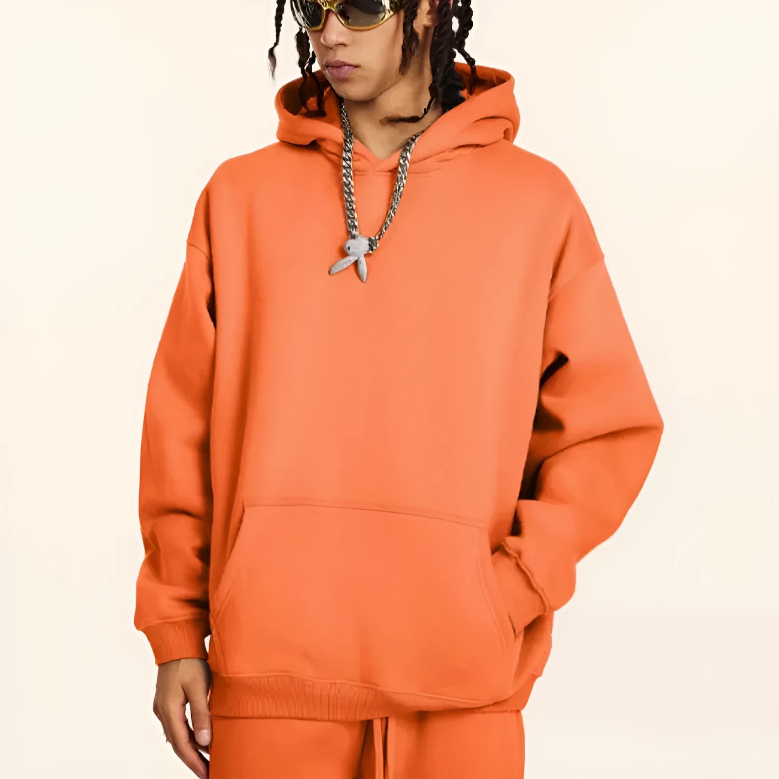 Man wearing a loose-fit grey cotton hooded sweater with drop shoulders, casual pullover style.