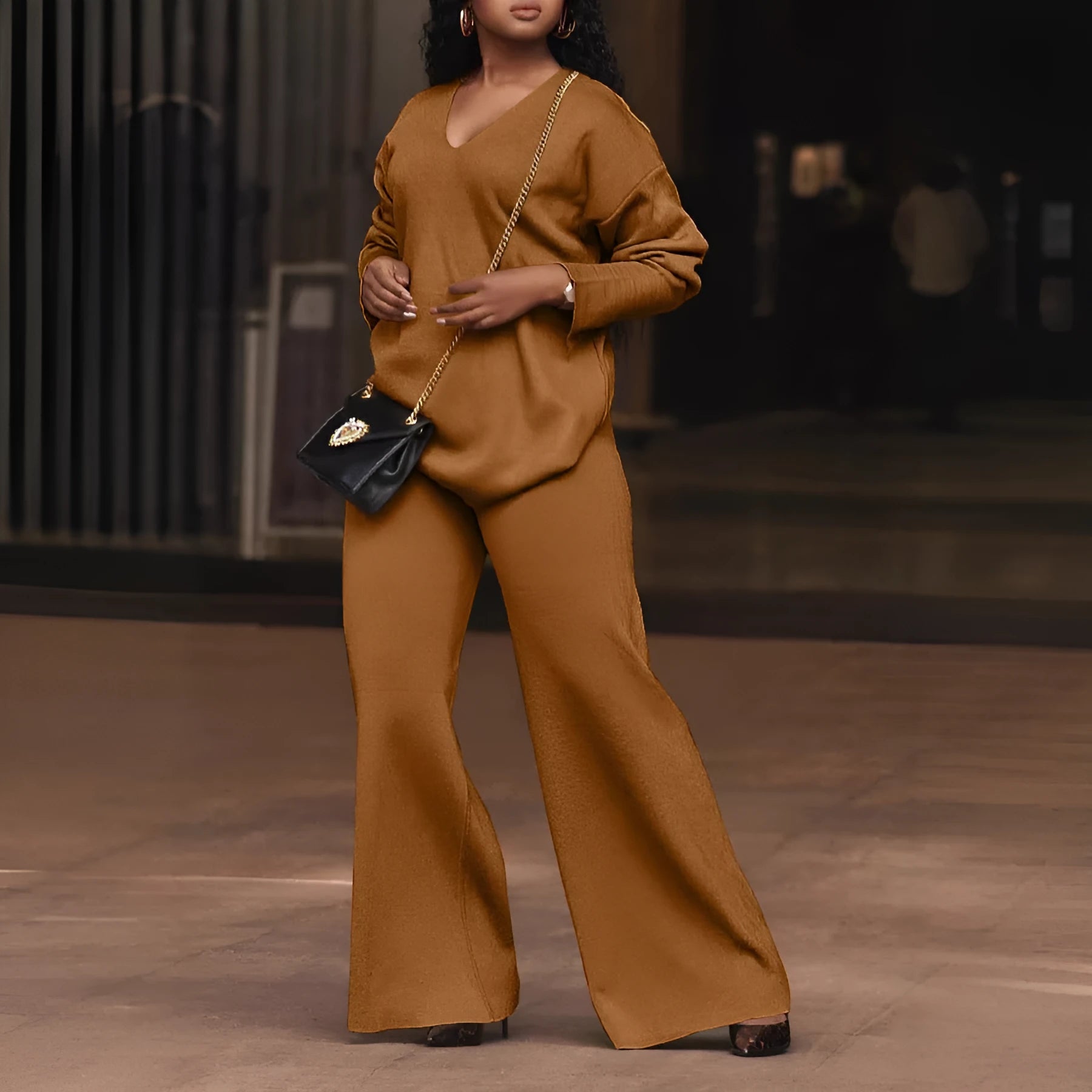 Women's brown suede two-piece suit with split sleeve top and matching trousers laid flat