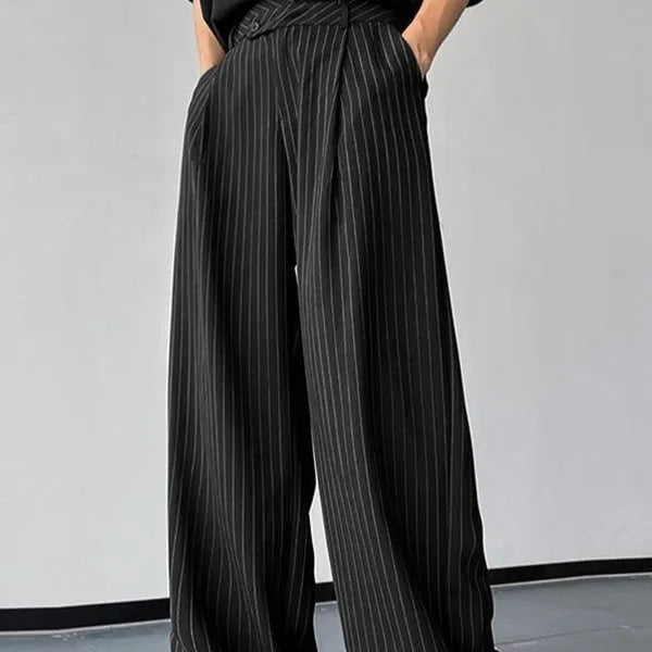 Man wearing black vertical stripe pleated casual trousers.
