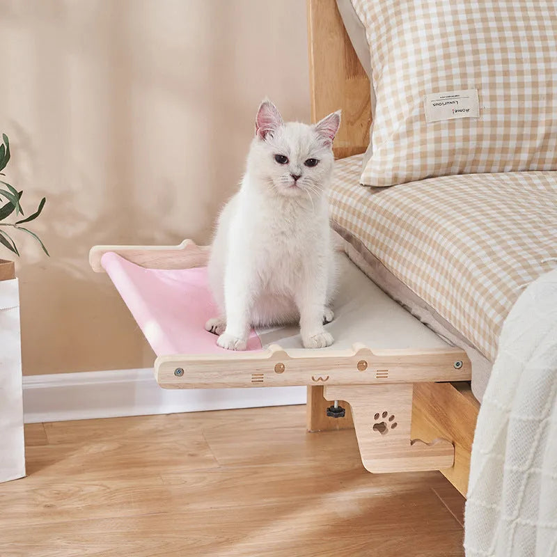 Wooden frame cat hanging bed with fabric hammock mounted by a window