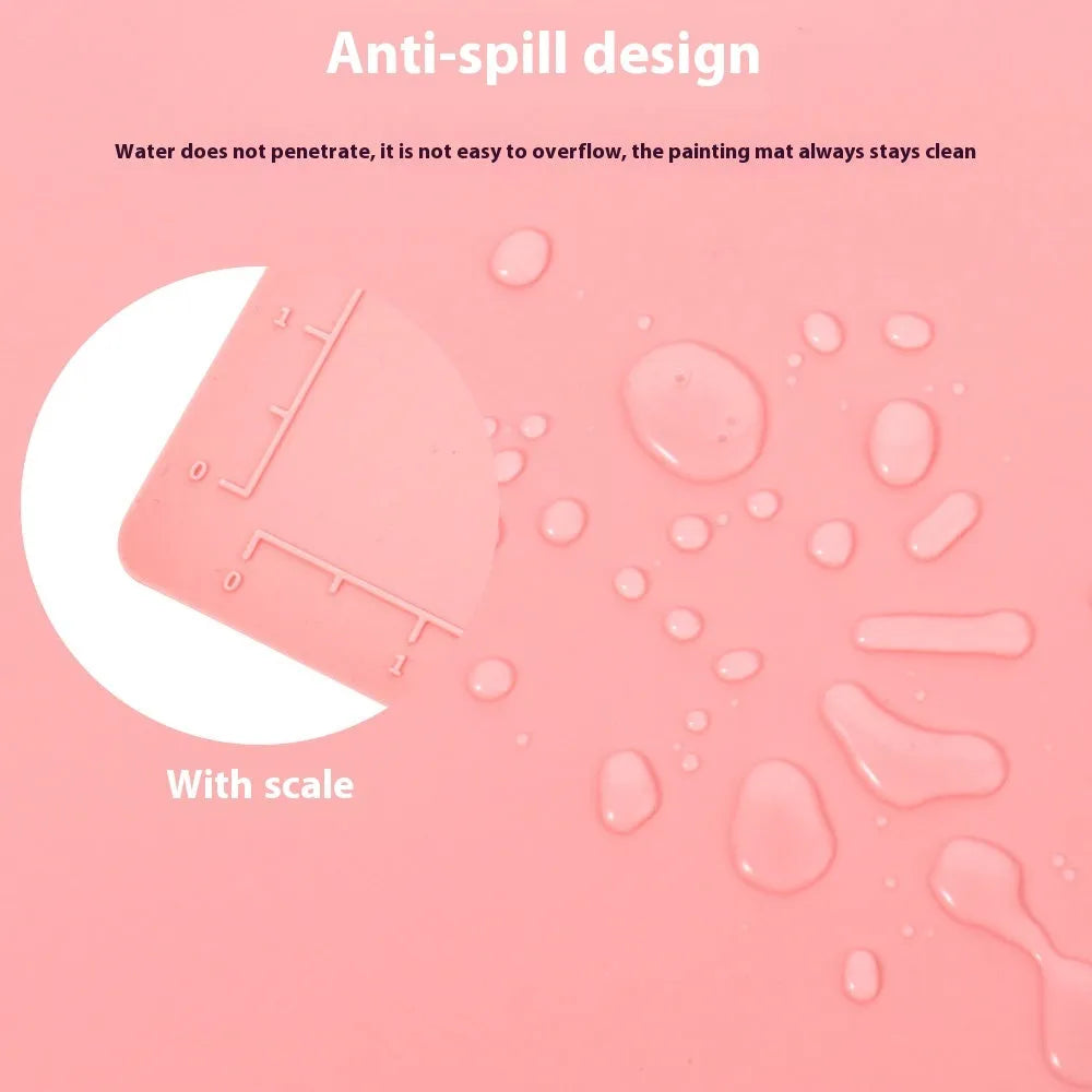 Light blue silicone painting mat with two recessed bowls for holding paint, placed on a wooden table.