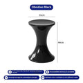 Green plastic hourglass style shoe changing stool on a wooden floor