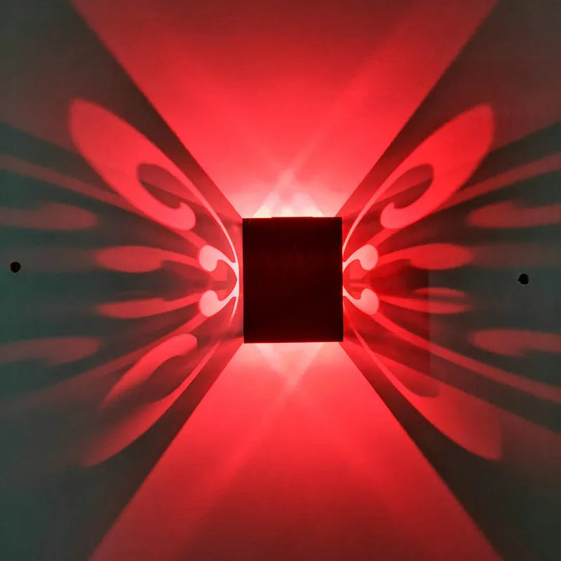 Modern silver aluminium butterfly-shaped LED wall lamp with remote control for changing light colours.