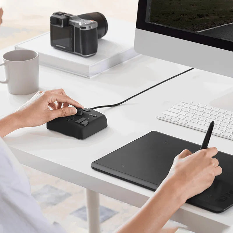 TourBox NEO custom auxiliary keyboard for video editing, showing black finish and compact tablet design.