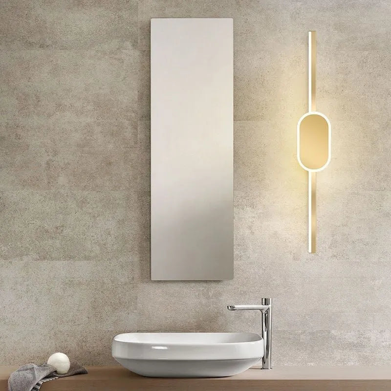 Gold-framed LED mirror cabinet with integrated makeup lights mounted on a bathroom wall.