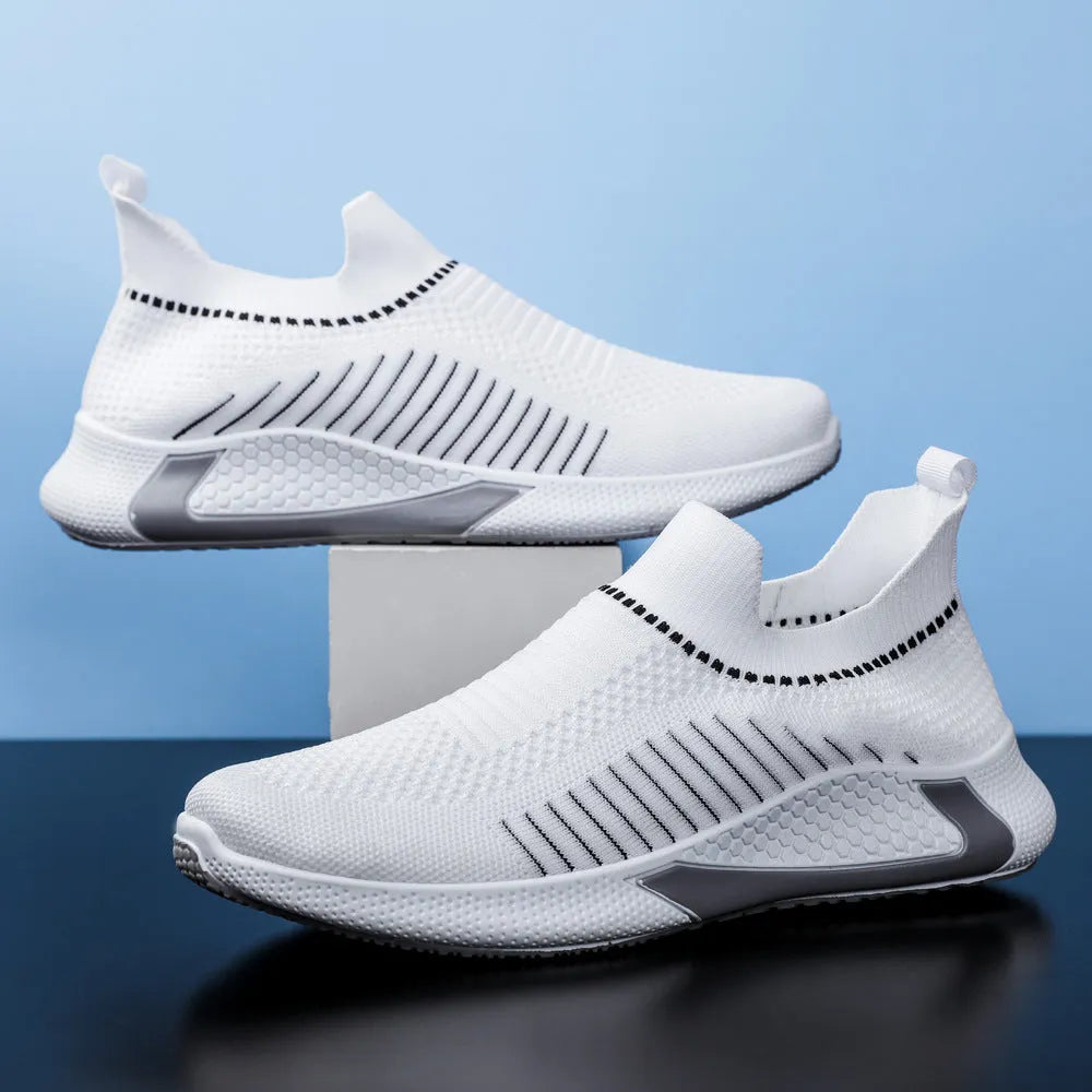 Men's black and white mesh slip-on sneakers with striped design and flat sole.