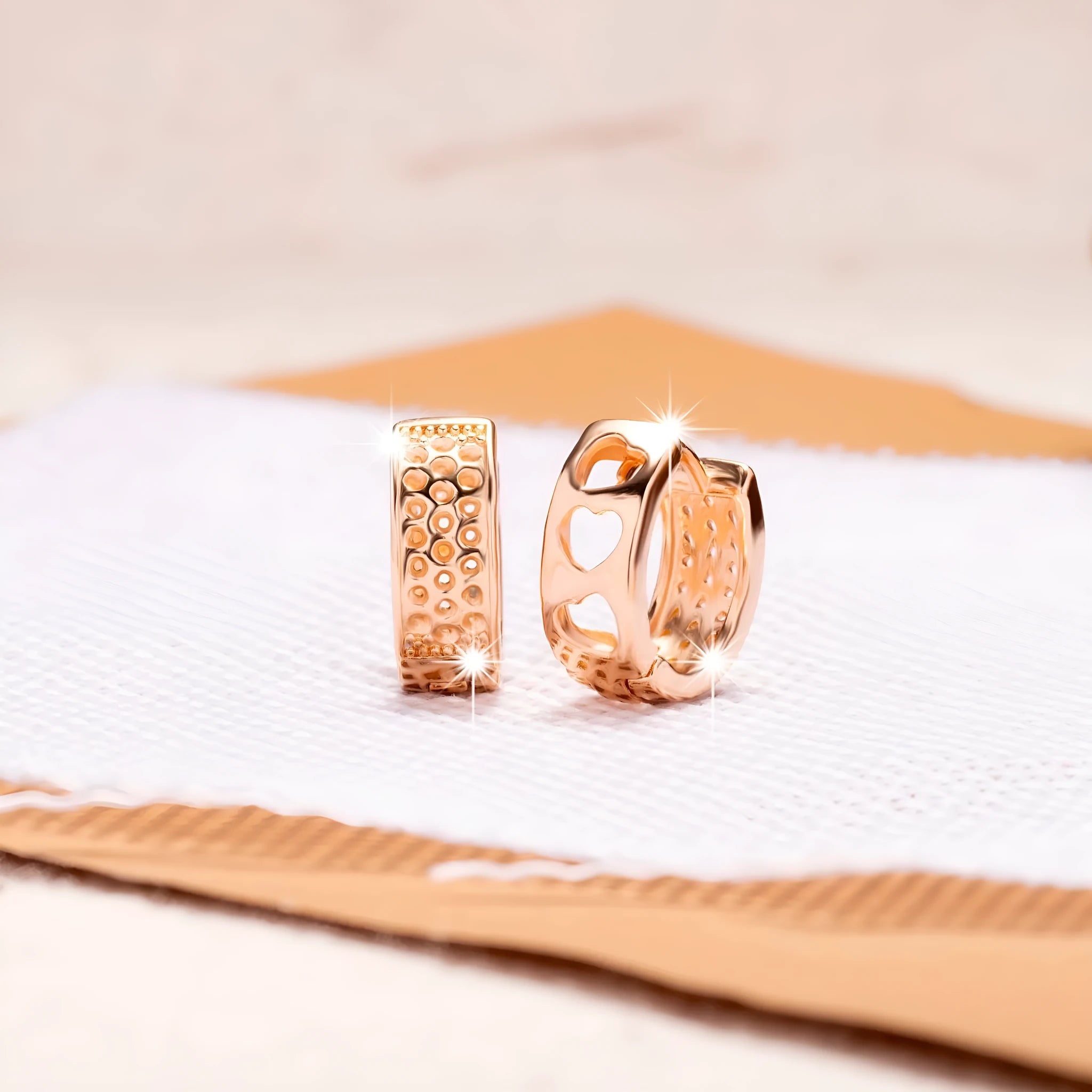 Rose gold circular women's earrings with a hollowed-out three-heart design.