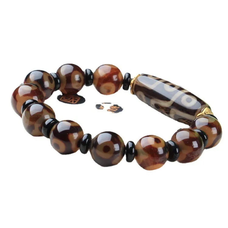 Distressed agate Tibet bead bracelet with three-eye motifs and multiple traditional bead styles on wrist